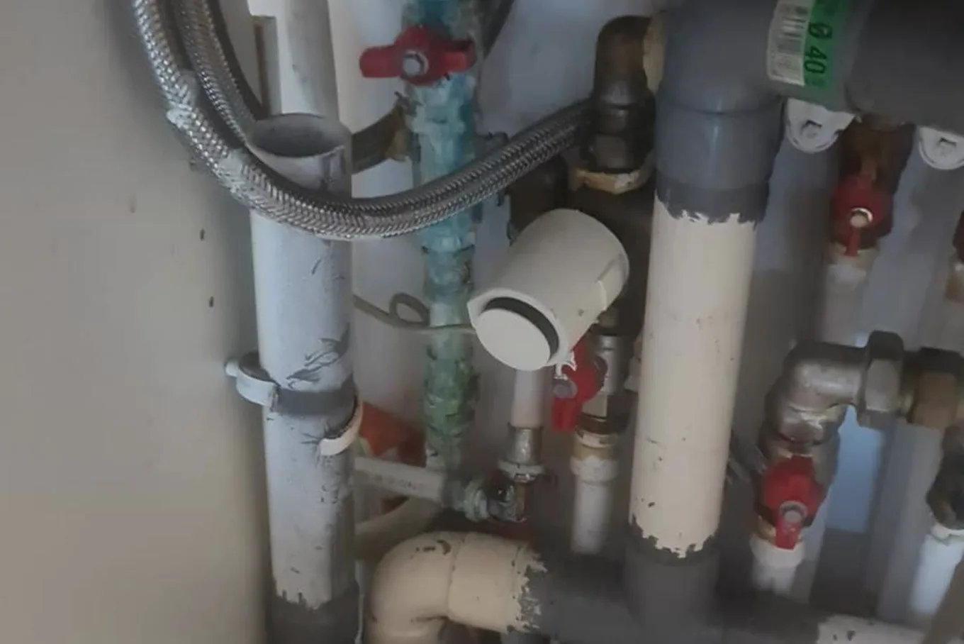 Plombier passant un furet dans une évacuation bouchée dans un appartement de Courbevoie